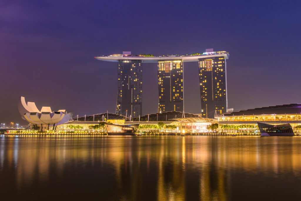 Marina Bay Sands hotel and ArtScience Museum illuminated at night, reflected in Marina Bay waters, Singapore