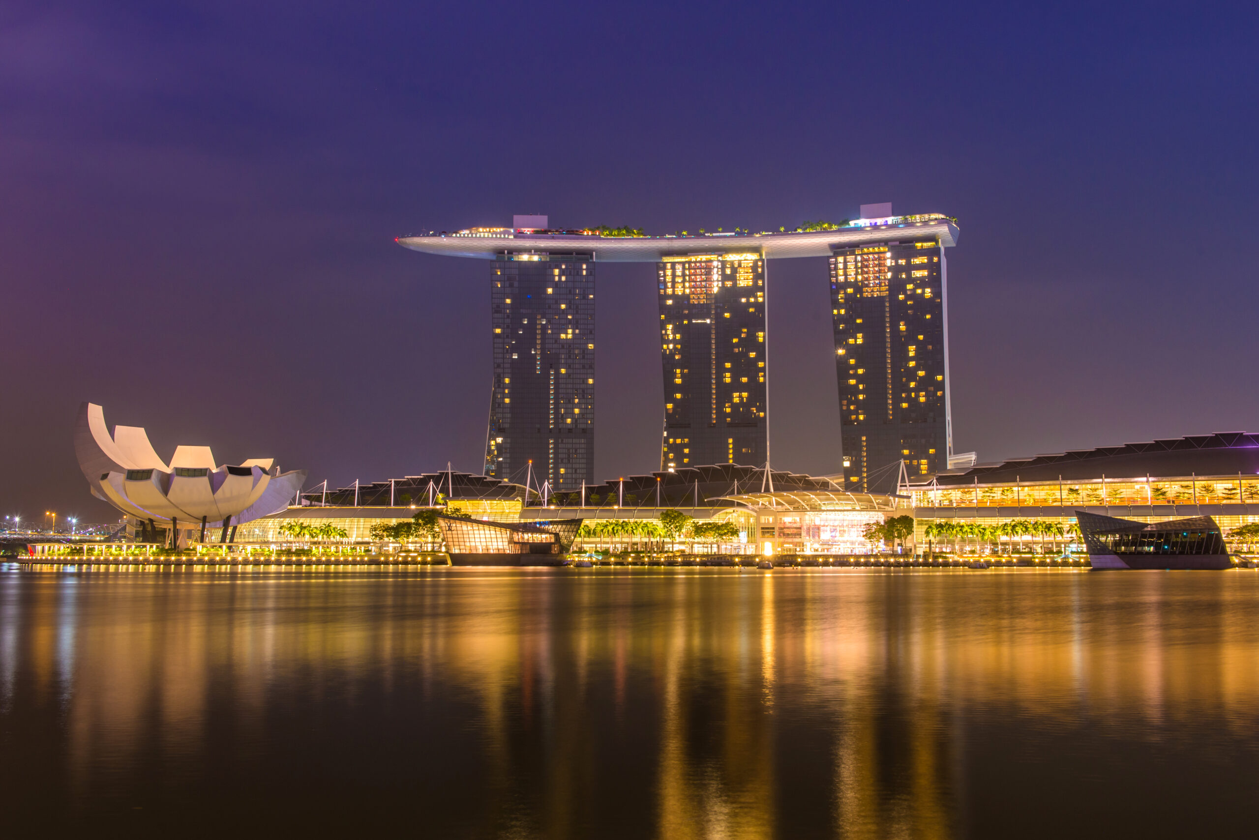 Marina Bay Sands hotel and ArtScience Museum illuminated at night, reflected in Marina Bay waters, Singapore